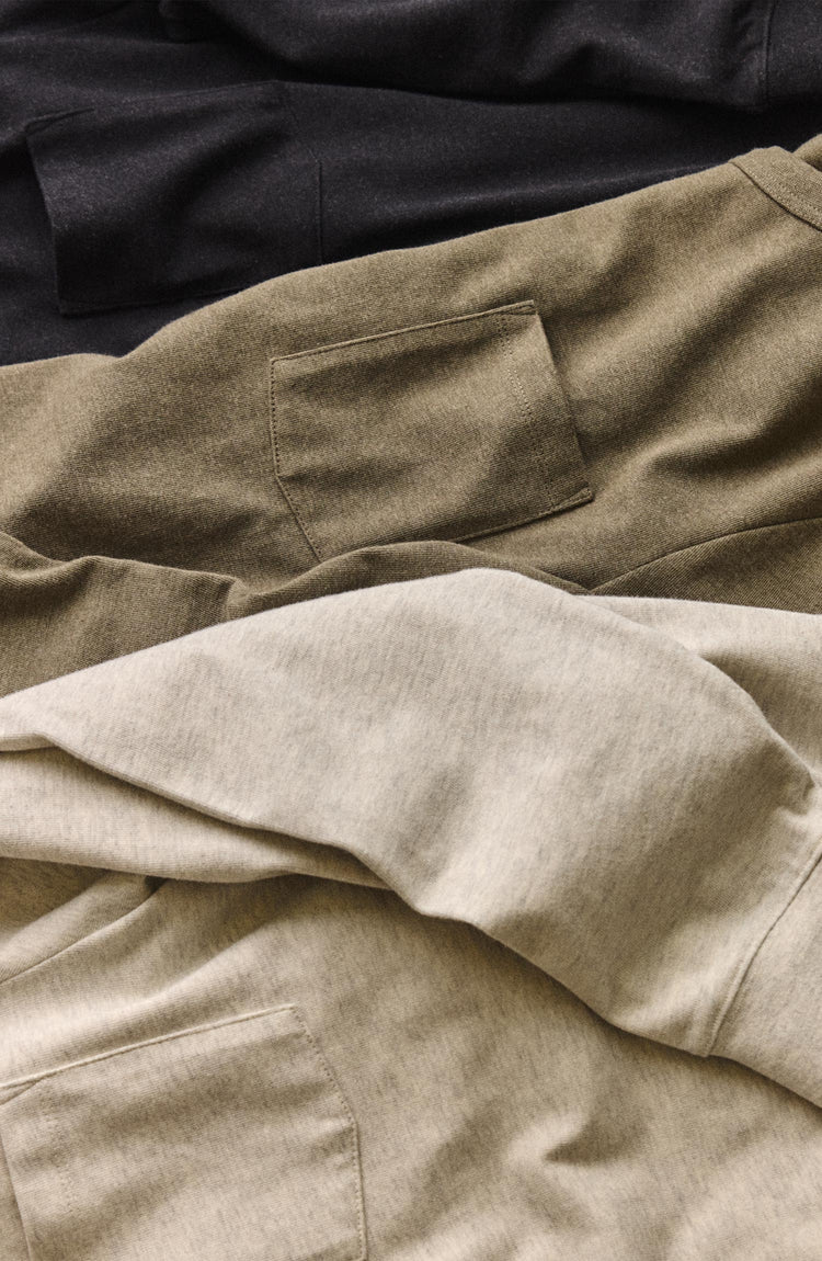 editorial flatlay of The Long Sleeve Shop Tee in Oat Twist next to other shop tees