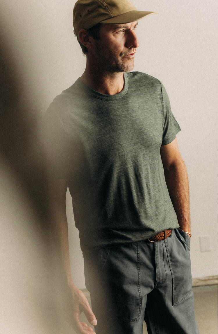 fit model sitting wearing The Merino Tee in Heather Army
