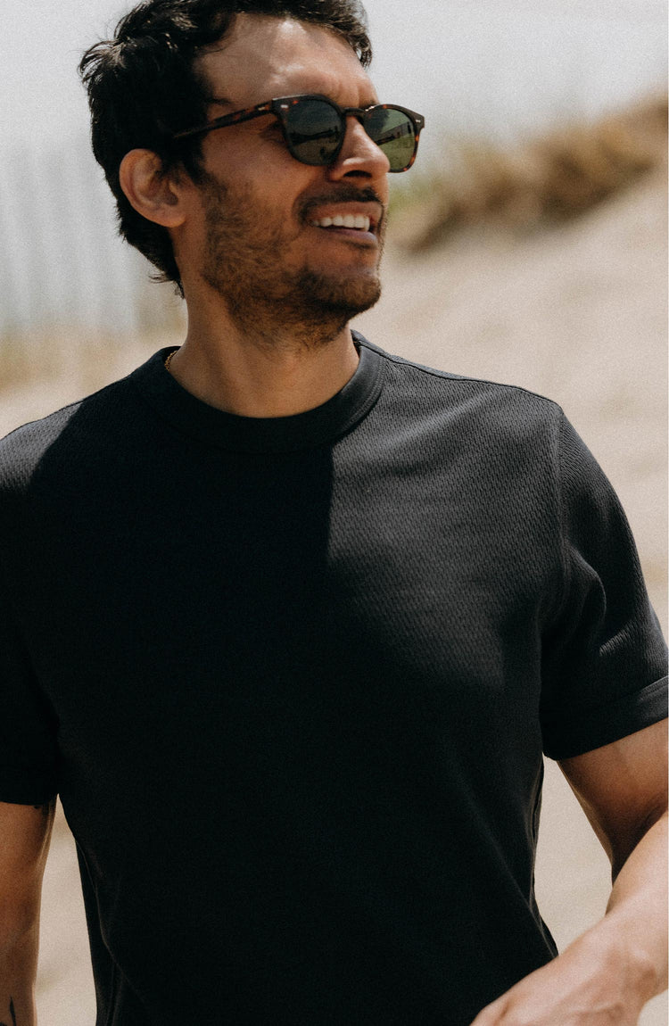 fit model with a camera around him wearing The Organic Cotton Short Sleeve Crew in Dark Navy Waffle