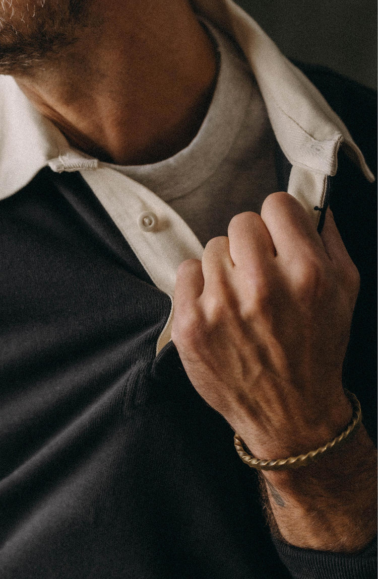 fit model leaning against the stairs wearing The Rugby Shirt in Coal