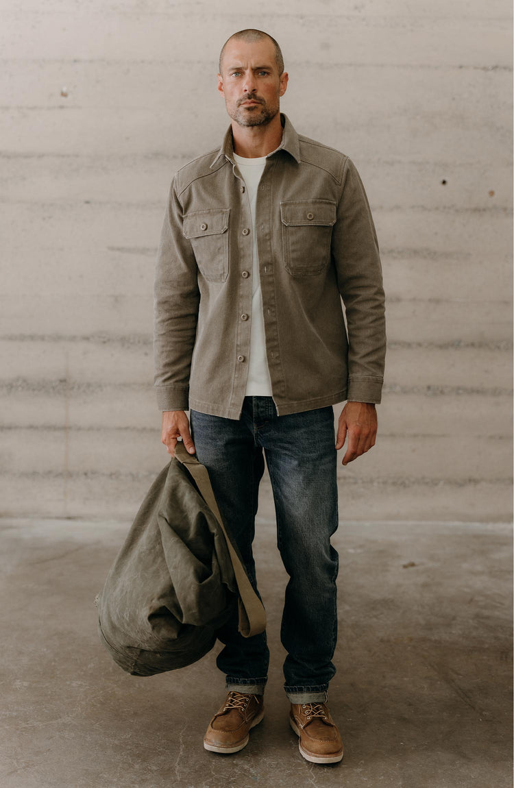 fit model holding a bag wearing The Shop Shirt in Stone Chipped Canvas