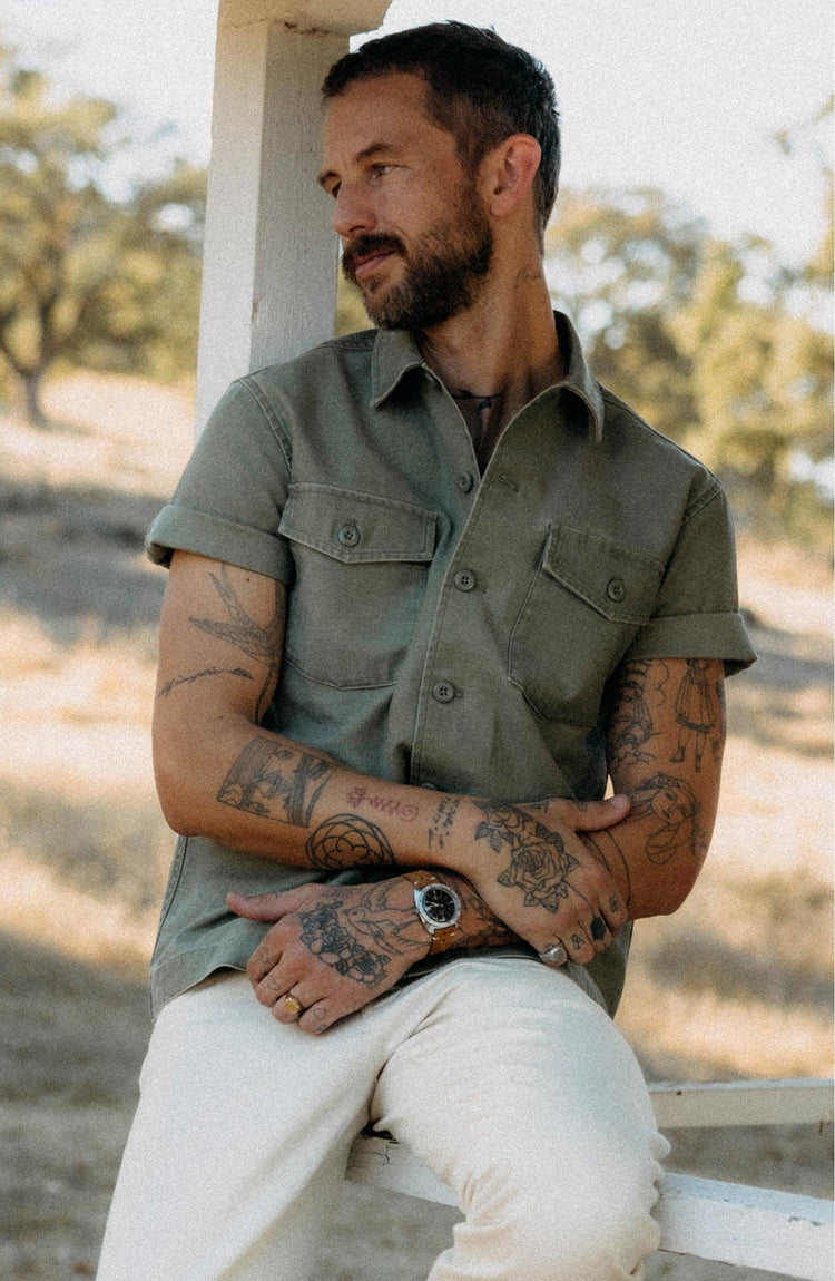 fit model posing in The Short Sleeve Surplus Shirt in Field Olive Reverse Sateen