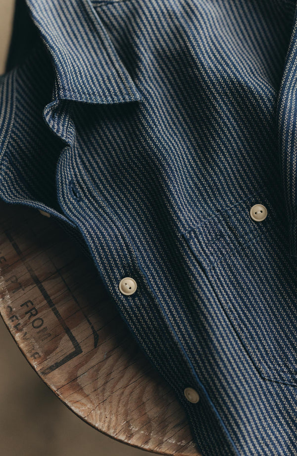 fit model leaning against the wall wearing The Short Sleeve Utility Shirt in Roped Indigo