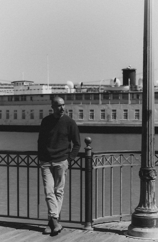 fit model leaning against the wall wearing The Sidecountry Crew in Heather Graphite Merino Waffle