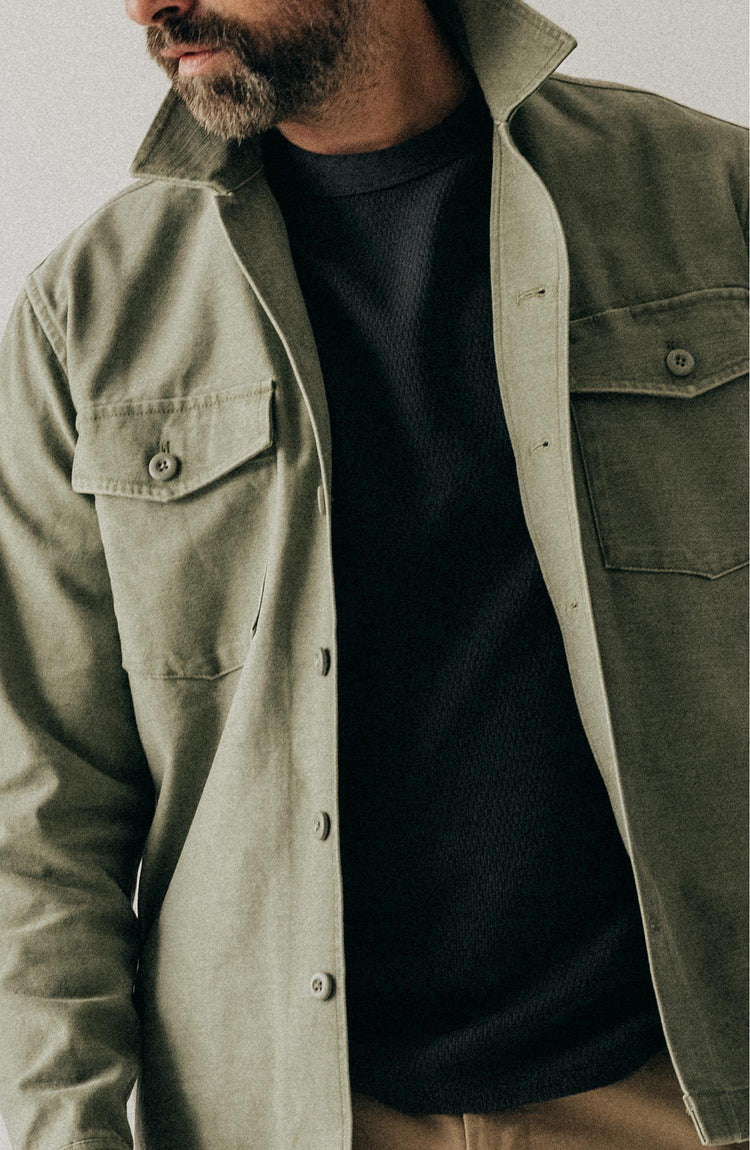 fit model sitting wearing The Surplus Shirt in Field Olive Reverse Sateen