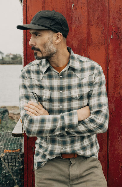 fit model leaning against the wall wearing The Western Shirt in Wetland Plaid