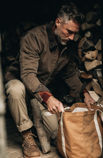 fit model sitting wearing The Workhorse Jacket in Aged Penny Chipped Canvas