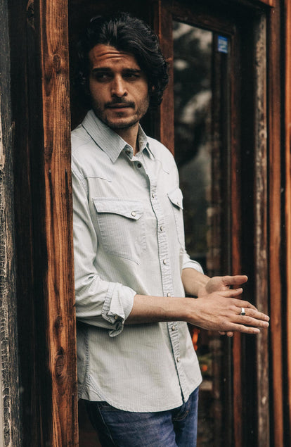 Our model standing in The Western Shirt in Bleached Indigo Stripe