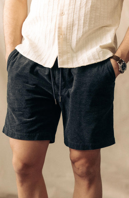 fit model with his hands in his pockets wearing The Apres Short in Heather Coal Pincord