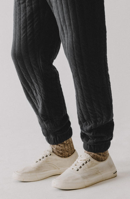 fit model showing off the cuffs on The Apres Pant in Heather Coal Quilted Jersey