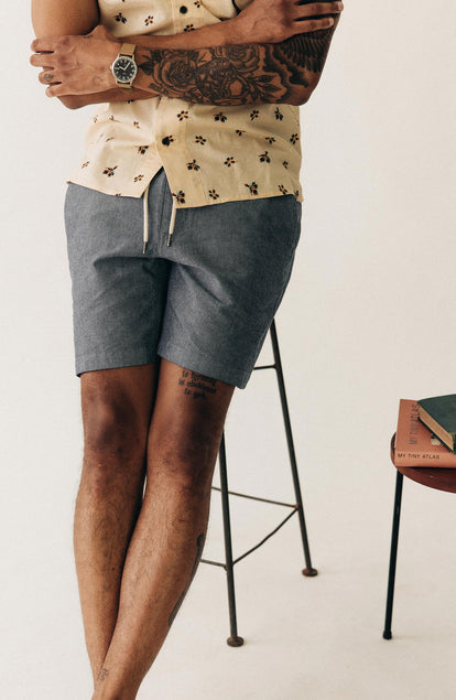 fit model sitting on a stool wearing The Apres Short in Indigo Chambray