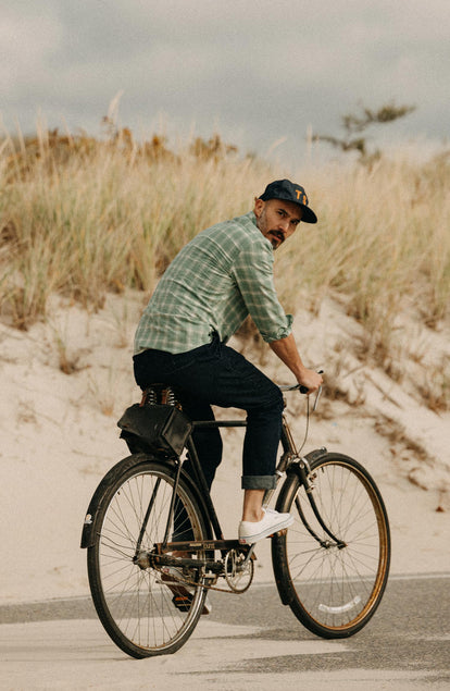 fit model riding a bike wearing The California in Sea Moss Plaid