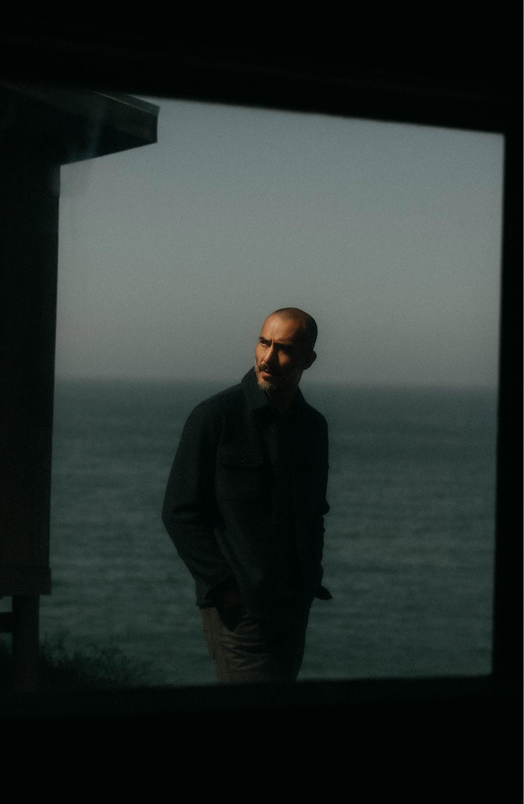 fit model leaning against the wall wearing The Connor Overshirt in Dark Navy Boucle