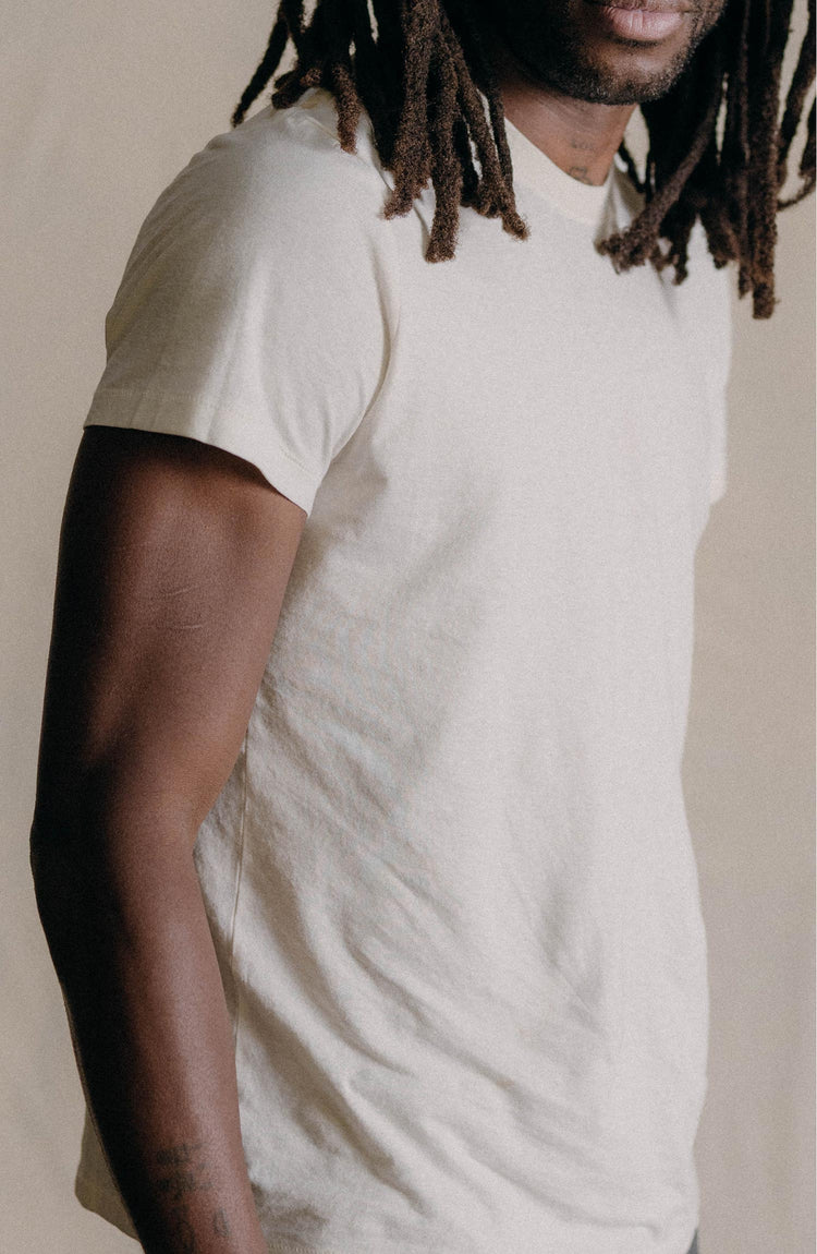 fit model leaning against the wall wearing The Cotton Hemp Tee in Natural