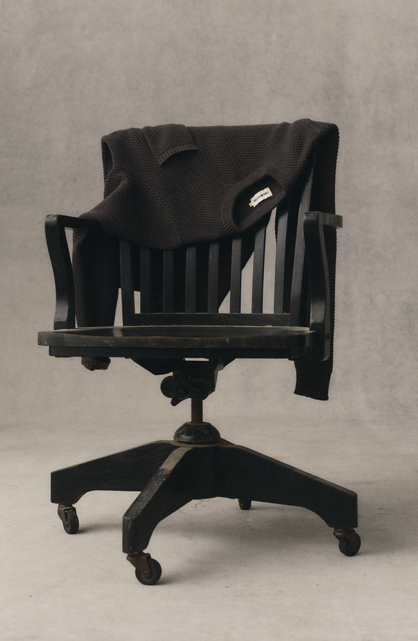 editorial image of The Crawford Crew Sweater in Charcoal on a chair