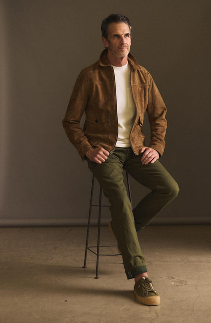 ffit model sitting on a stool wearing The Democratic Jean in Olive Nihon Menpu Selvage
