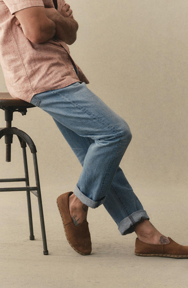 fit model sitting wearing The Democratic Jean in Light Wash Hemp Denim