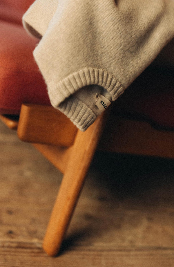 editorial image of The Eastmoor Sweater in Heather Ivory Wool on a chair