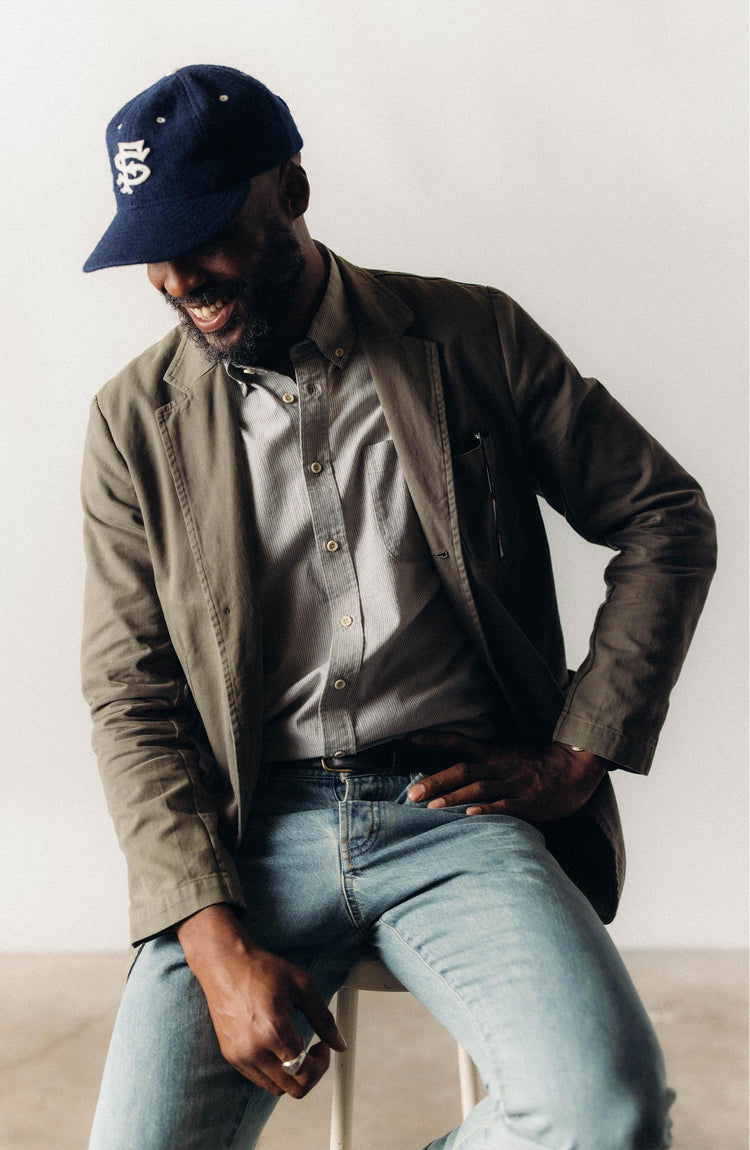 fit model leaning against a bar wearing The Foundation Sportcoat in Organic Smoked Olive Twill