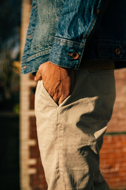A pair of Foundation Pants folded on a black background, showing the back pocket.