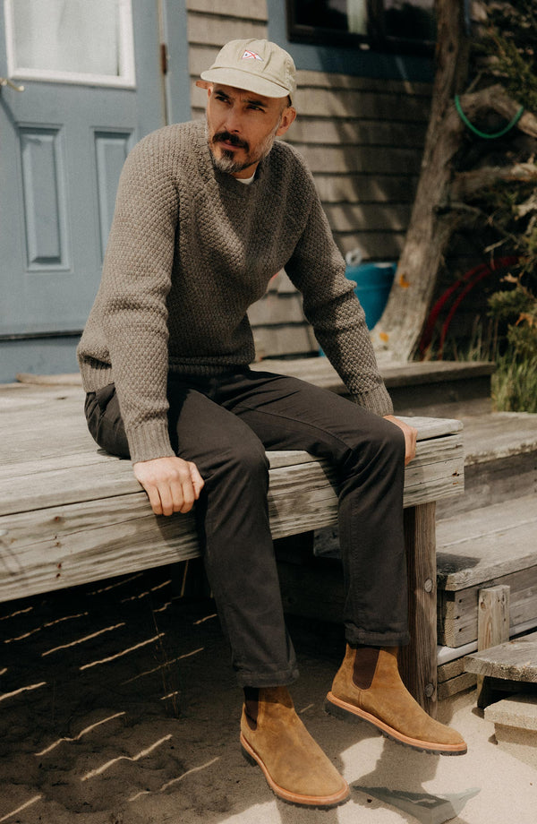 A pair of Foundation Pants folded on a black background, showing the back pocket.