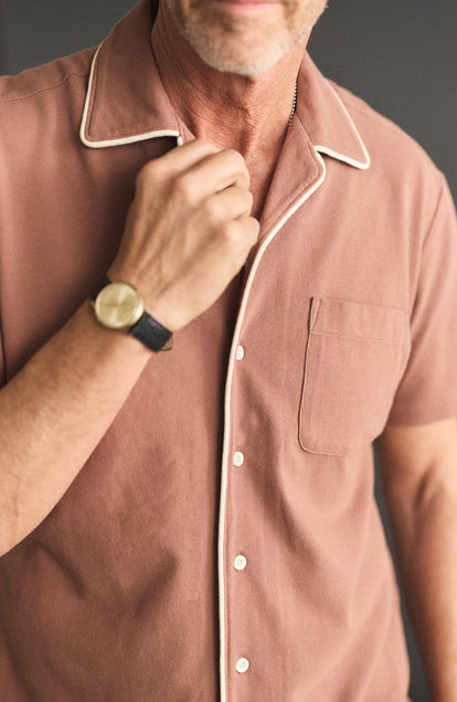 fit model adjusting the collar on The Harwich Shirt in Faded Brick Tipped Pique