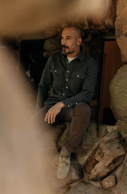 fit model leaning on the wall wearing The Ledge Shirt in Deep Sea Twill