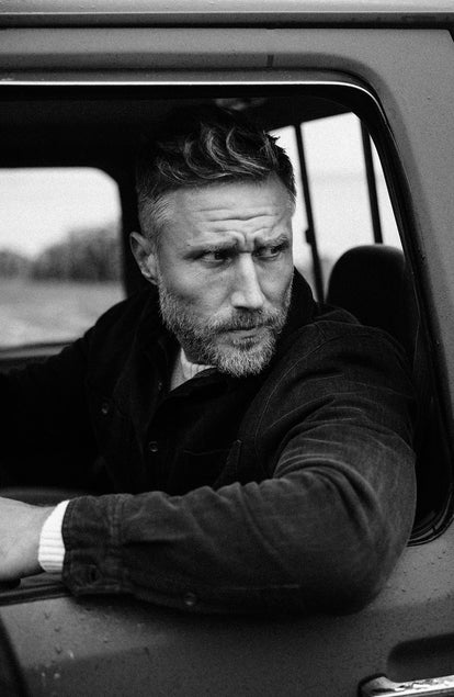 model sitting in a truck in The Lined Utility Shirt in Washed Black Denim