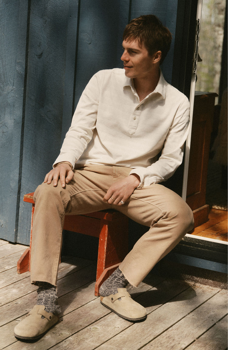 fit model posing in The Long Sleeve Polo in Vintage White Knit Stripe