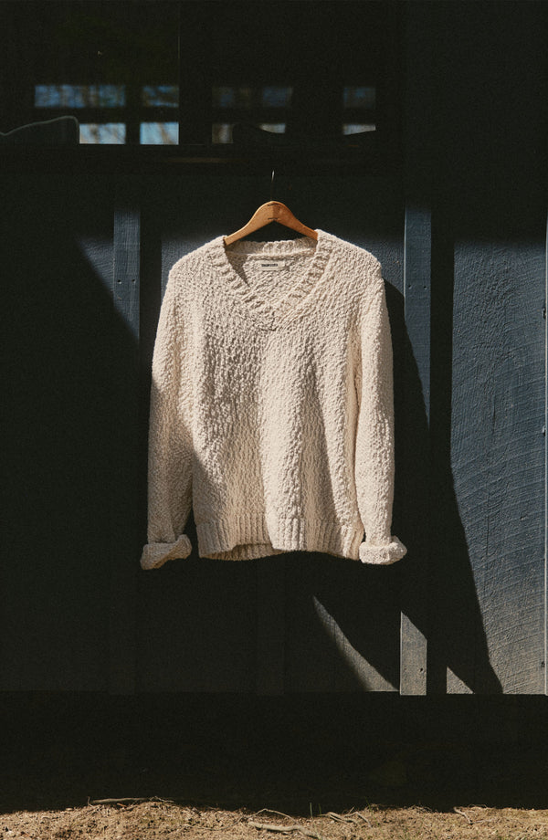 editorial image of The Match V-Neck Sweater in Vintage White Slub hanging