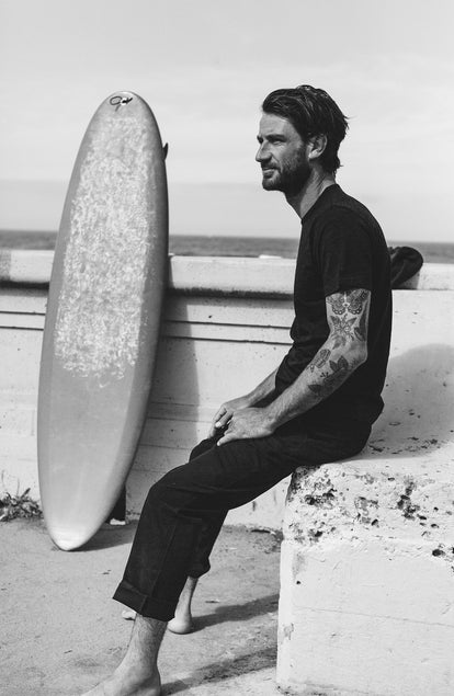 our guy rocking the merino tee near the beach—split shot