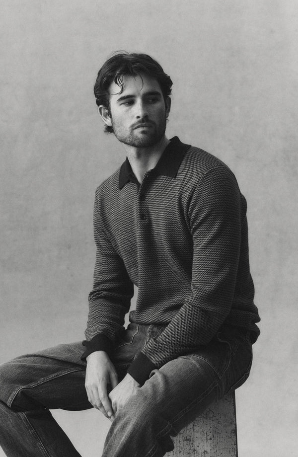 fit model sitting wearing The Newton Sweater Polo in Burgundy Birdseye Merino