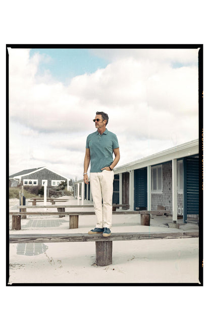 fit model standing on a bench wearing The Organic Cotton Polo in Washed Indigo