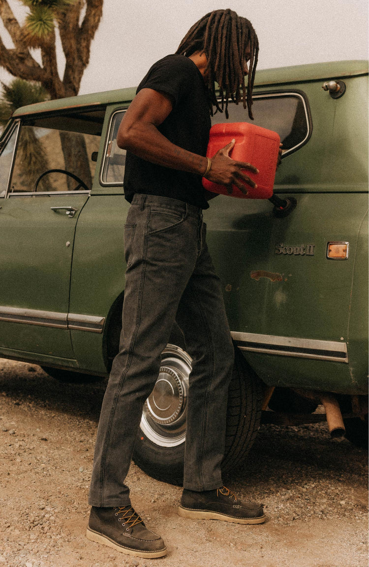 fit model filling up a car with gas wearing The Organic Cotton Tee in Black Indigo