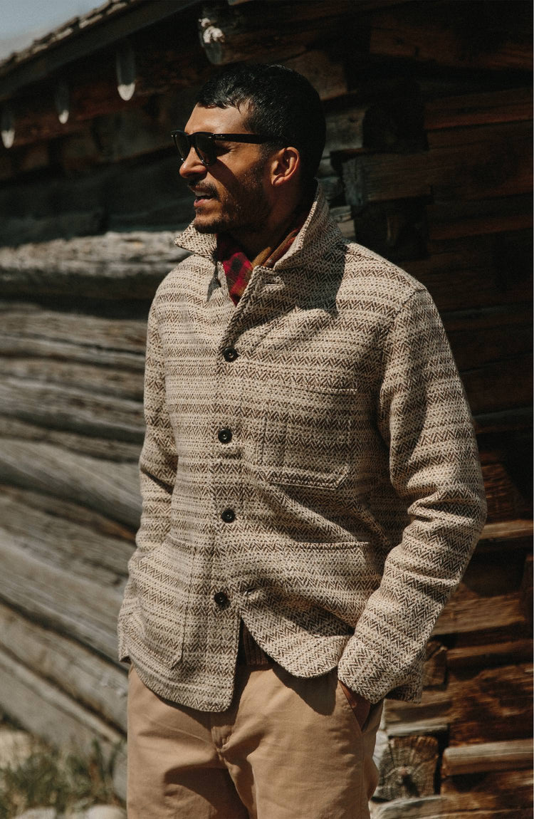 Our guy wearing The Ojai Jacket in Espresso Herringbone Wool in front of a cabin in Wyoming