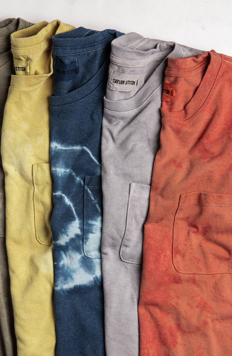 Botanical dyed tees, folded, overlapping on a natural background.