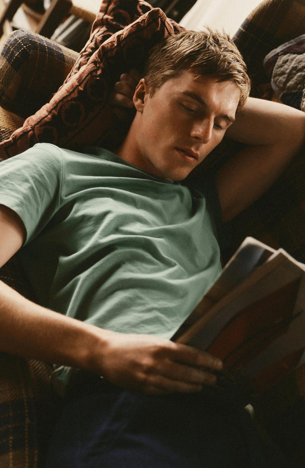 fit model sitting wearing The Regenerative Cotton Tee in Faded Pine