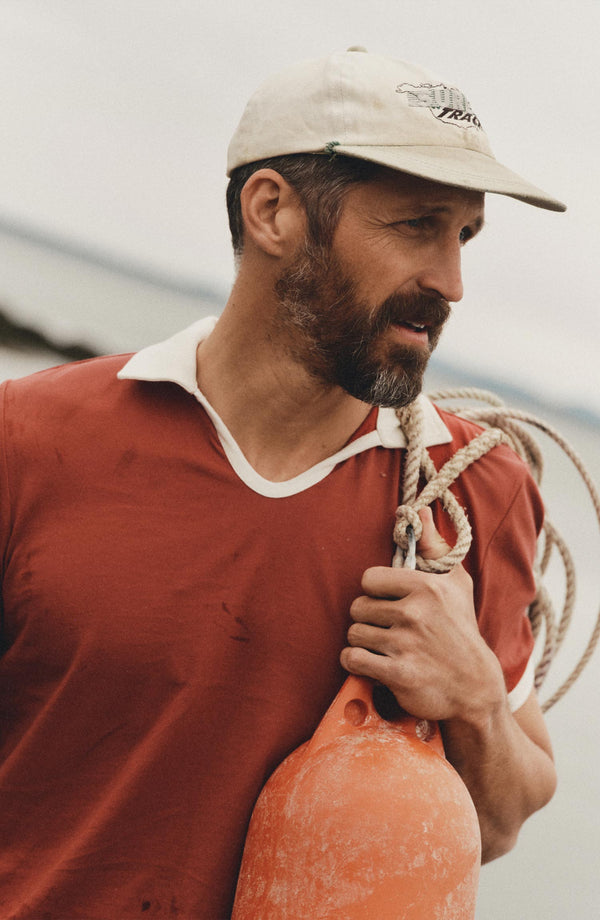 fit model holding a buoy wearing The Ripper Polo in Canyon