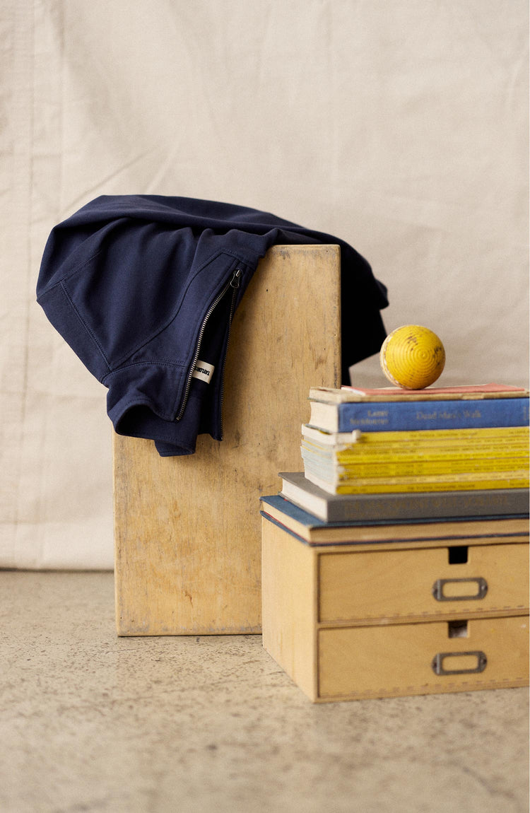 editorial image of The Rugby Quarter Zip in Faded Navy on a chair