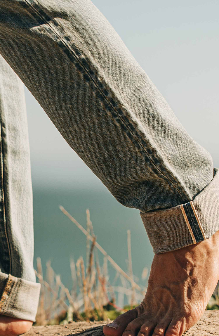 our fit model wearing the 24 month wash denim on the beach—cropped shot of legs
