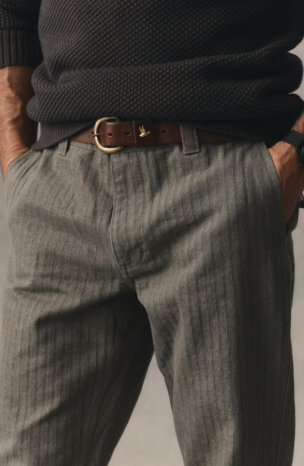 fit model with his hands in his pockets wearing The Emlen Pant in Smoked Olive Herringbone