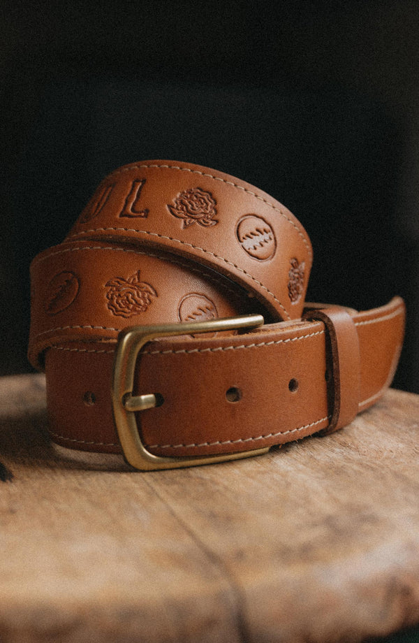 flatlay of The Tour Belt in Washed Saddle rolled up
