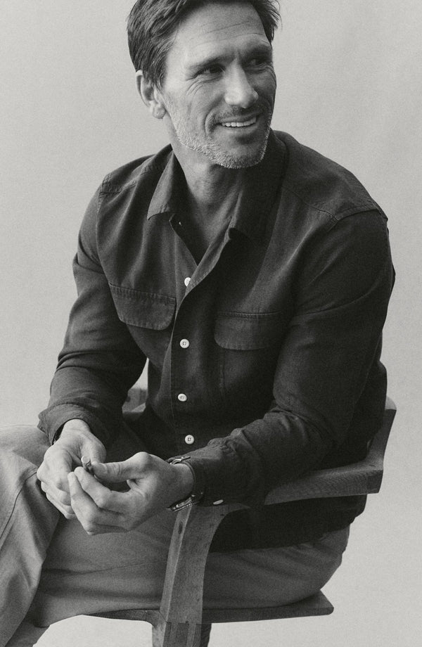 fit model sitting wearing The Shore Shirt in Navy Tencel