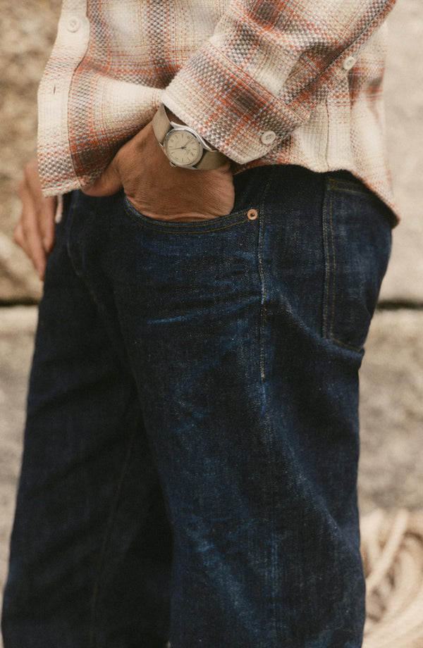 fit model with his hand in his pocket wearing The Straight Jean in Rinsed Organic Selvedge