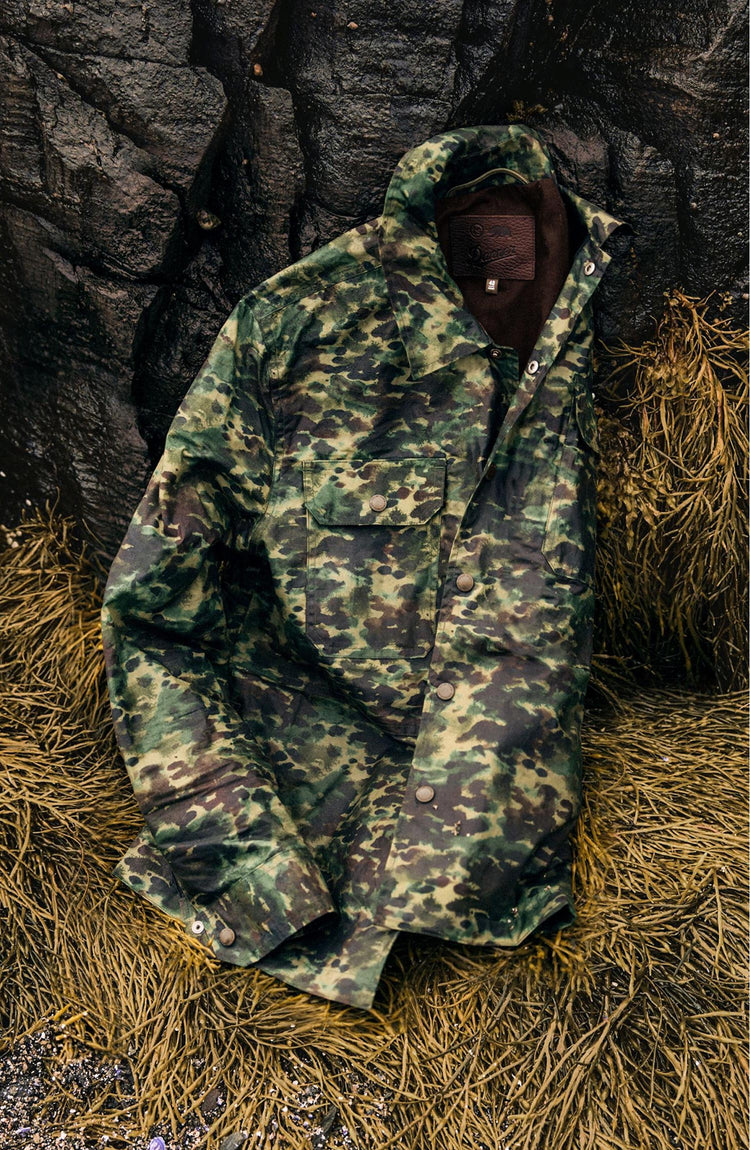 The Venture Jacket in Painted Camo Waxed Canvas on the ground