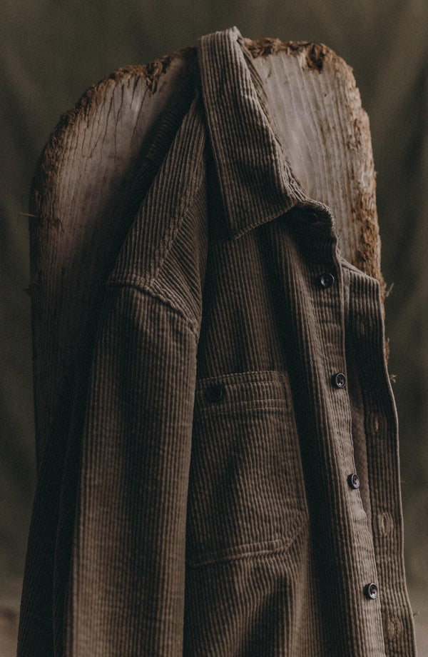 editorial image of The Utility Shirt in Fatigue Olive Corduroy hanging on a board