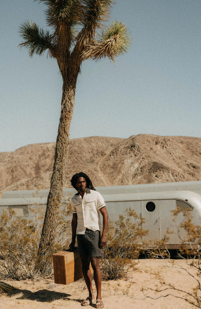 fit model holding a suitcase wearing The Weber Shirt in Vintage White
