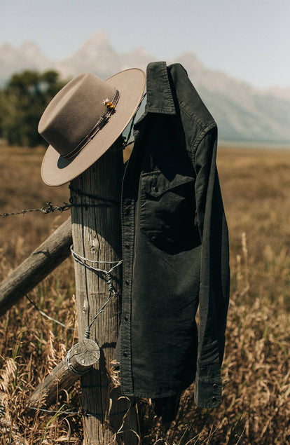 Shot of the shirt and a cowboy hat hanging on a fence post