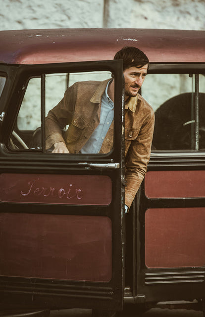 Exiting a wood-panelled vehicle in a nice Long Haul Jacket and crisp Blue Oxford.