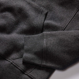 material shot of the ribbed cuffs and kangaroo pocket on The Horizon Shawl Pullover in Coal Heather